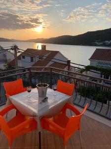 een tafel en stoelen op een balkon met uitzicht op het water bij Villa A'Mare in Seget Vranjica