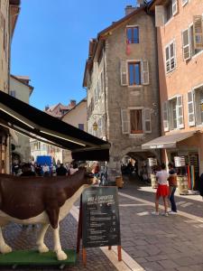 a statue of a cow on a city street at 2 Pieces cosy in Annecy