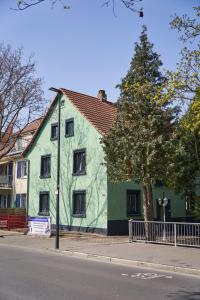 een groen huis aan de kant van een straat bij Greenhome Lörrach -Ihre Unterkunft im 3-Ländereck- in Lörrach