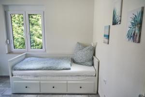 a small bed in a room with a window at Greenhome Lörrach -Ihre Unterkunft im 3-Ländereck- in Lörrach