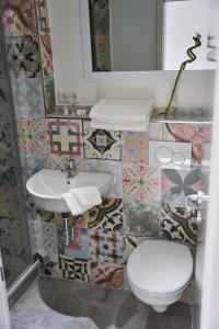 La salle de bains est pourvue d'un lavabo, de toilettes et d'un miroir. dans l'établissement Greenhome Lörrach -Ihre Unterkunft im 3-Ländereck-, à Lörrach