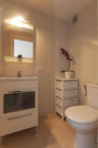 een badkamer met een toilet, een wastafel en een spiegel bij 1213 SANT JOAN 200m Playa in Roses