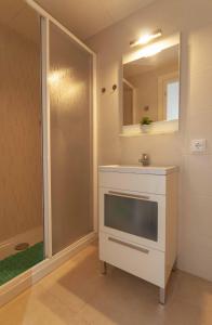 een badkamer met een douche, een wastafel en een spiegel bij 1213 SANT JOAN 200m Playa in Roses