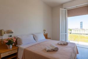 a bedroom with a bed with two towels on it at Hotel Atlas in Cesenatico