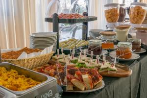 a buffet with sandwiches and other food on a table at Hotel Atlas in Cesenatico