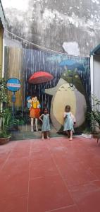 two little girls standing in the rain with umbrellas at Mai Homestay in Sầm Sơn
