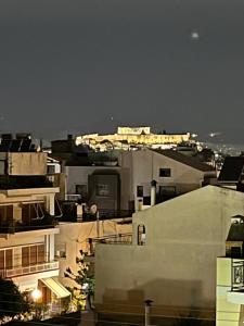 vistas a una ciudad por la noche con edificios en Acropolis View, en Atenas