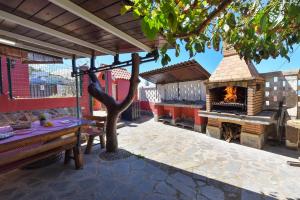 a patio with a pizza oven and a table and a fireplace at Traditional Arucas by VillaGranCanaria in Arucas