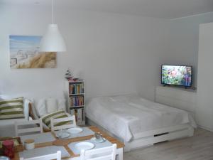 コウォブジェクにあるPrzytulny Apartament Kołobrzeg - Podczeleのベッドルーム1室(ベッド1台、壁にテレビ付)