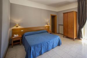 a bedroom with a blue bed and a wooden headboard at Hotel Roccaporena & Margherita in Roccaporena