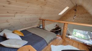 a bedroom with a bed in a log cabin at FruPi Apartmanok - A kis ház in Ostoros