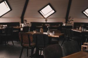 - une salle à manger avec des tables, des chaises et des lucarnes dans l'établissement Doro Camp Lapland, à Dorotea