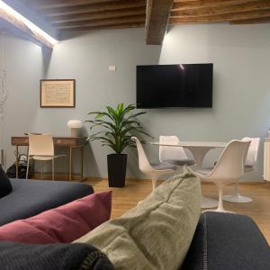 La dimora Blu في بارما: غرفة معيشة مع طاولة وتلفزيون على الحائط