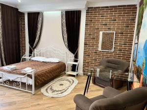 a bedroom with a bed and a brick wall at Lavender Night Apartments in Chernivtsi