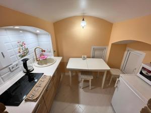 a small kitchen with a sink and a table at Lavender Night Apartments in Chernivtsi