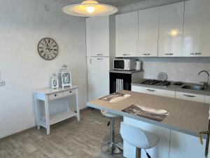 a kitchen with a counter and a clock on the wall at Appartamento bianco in Menaggio