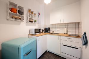 eine Küche mit einem blauen Kühlschrank und weißen Schränken in der Unterkunft Altstadtwohnung TOP Lage Zentrum mit Terrasse in Dresden