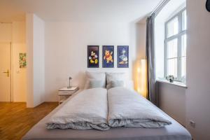 ein großes Bett in einem weißen Zimmer mit Fenster in der Unterkunft Altstadtwohnung TOP Lage Zentrum mit Terrasse in Dresden