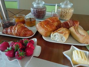 two plates of croissants and strawberries on a table at Les chambres du Vert Galant "La campagne qui murmure" in Verlinghem