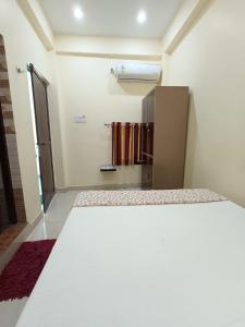 a small room with a bed and a refrigerator at Hotel Saraswati Palace in Varanasi +33 photos