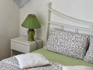 a bedroom with a bed with a lamp on a night stand at B&B By Lussy - Camera Verde in Menaggio