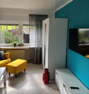 a living room with a yellow chair and a white refrigerator at Hannis-Hof in Meinerzhagen