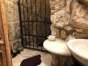 a stone bathroom with a sink and a black gate at Chateau du Roi in Mi‘ilyā