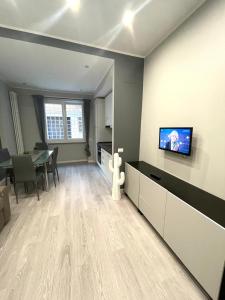 un soggiorno con un tavolo e una TV a parete di AL.MA GUEST HOUSE a Roma