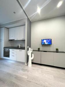 una cucina con mobili bianchi e un cactus al centro di AL.MA GUEST HOUSE a Roma