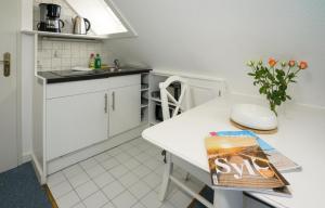 ヘルヌムにあるApp.1 Seeblickの小さなキッチン(白いカウンター、テーブル付)