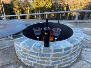 eine Flasche Wein und zwei Gläser in einer Feuerstelle in der Unterkunft Almhütten Skorianz in Klippitztorl