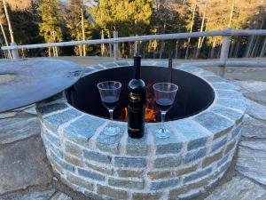 a bottle of wine and two glasses in a fire pit at Almhütten Skorianz in Klippitztorl