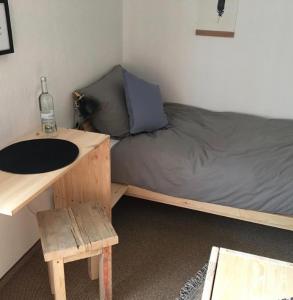 a bedroom with a bed and a desk with a bottle of water at Pension Alois Hennecke in Schmallenberg