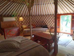um quarto com uma cama e um sofá numa tenda em Yourte Bourgogne em Corvol-dʼEmbernard
