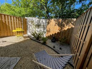 een achtertuin met een hek en een tafel en een stoel bij Magnifique cocon sous les chênes in Saint-Martin-de-Londres