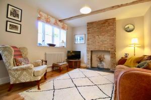 a living room with a couch and a fireplace at 14th century Rose cottage, Centre of Alfriston By Air Premier in Alfriston
