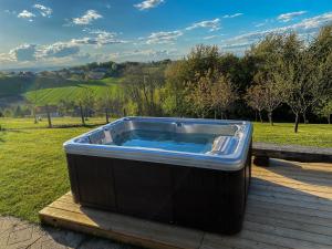 a hot tub sitting on a deck in a field at Wellness hiška Robida in Ljutomer