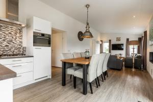 a kitchen and dining room with a wooden table and chairs at Schaelsbergerbosch in Bemelen