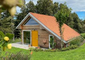 una piccola casa in legno con tetto arancione di Wellness hiška Robida a Ljutomer