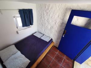 Habitación pequeña con puerta azul y ventana en Kamena kućica en Gdinj