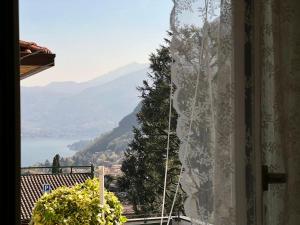 a room with a window with a view of a mountain at B&B By Lussy - Camera Verde in Menaggio