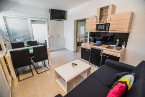 a living room with a couch and a table and a kitchen at Downtown Park Apartments with Balcony in Vodice