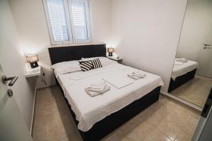 a small bedroom with a bed and a mirror at Downtown Park Apartments with Balcony in Vodice