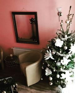 a christmas tree in a living room with a mirror at Pension Oderblick in Frankfurt Oder