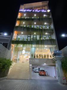 a large building with a car garage at night at Amely Hotel in Bến Cát