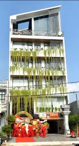 a building with a group of people in front of it at Amely Hotel in Bến Cát