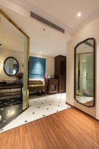 a living room with a mirror and a bed at Hanoi Tirant Hotel in Hanoi