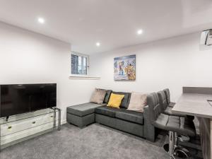 sala de estar con sofá y TV de pantalla plana en Casa Fresa - Castle Heights Apartment, en Dundee