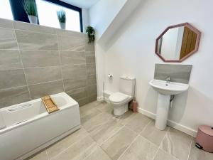 a bathroom with a sink and a toilet and a mirror at Minster Peek With Free Parking in York