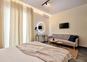 una camera da letto con un letto e un divano di Amaroo Suites - 250m from the beach, by ZanteWize a Laganas